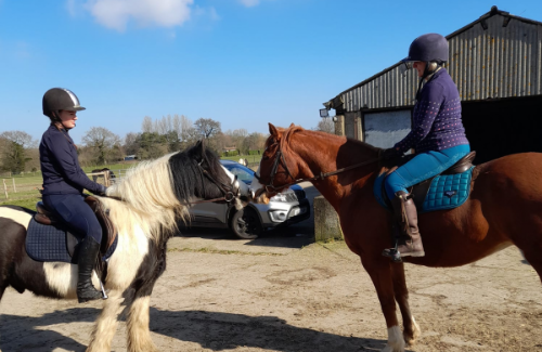Two people riding horses at croft farm riding centre